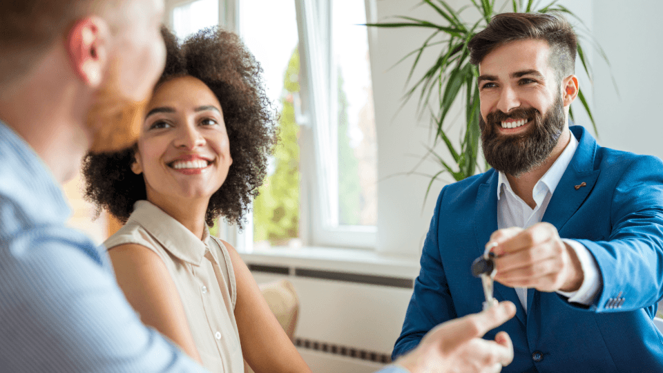 Realtor Handing Keys to Young Couple
